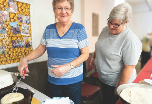man standing talking and people sitting